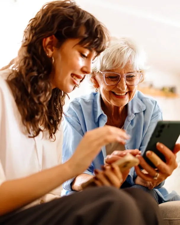 young woman helping older woman on phone